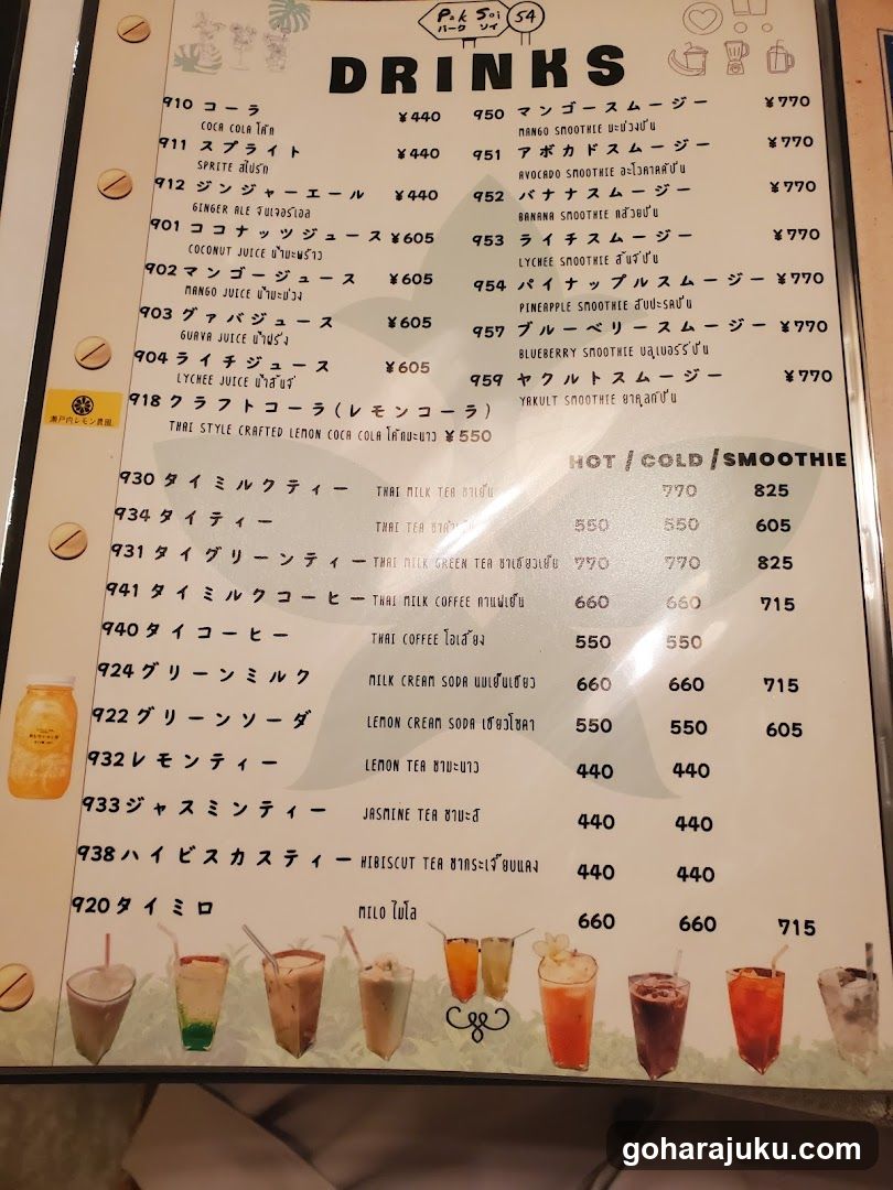 A printed menu board displaying a variety of smoothies, juices, and cold drinks with prices in Thai Baht. The menu includes items like coconut juice, mango smoothie, and green tea milk.