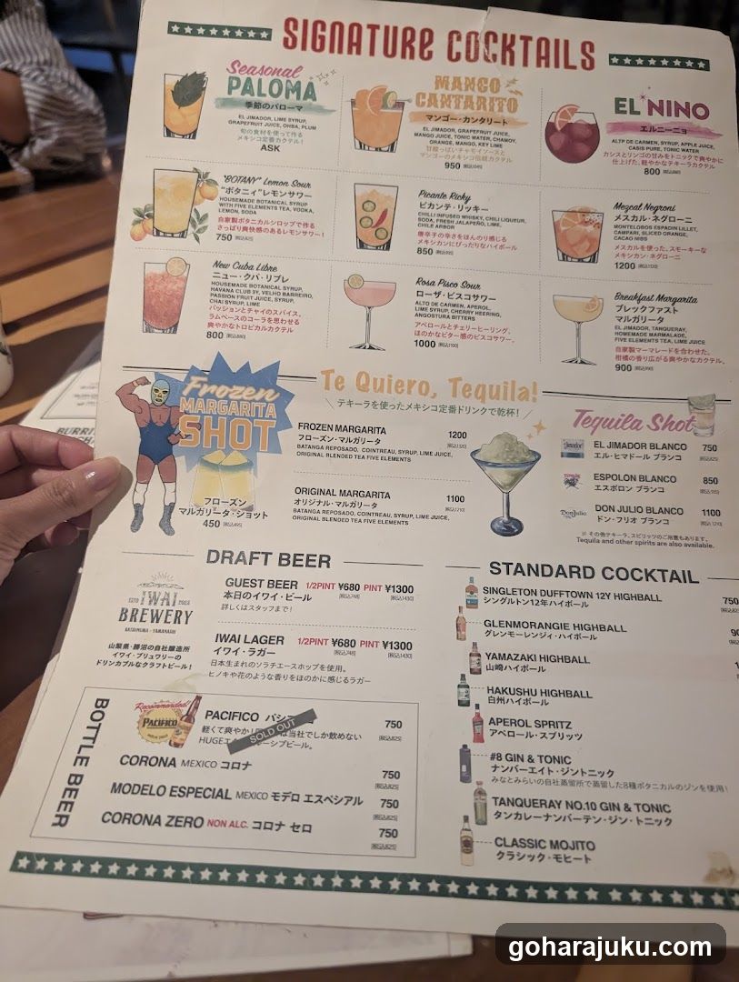 A printed menu showing signature cocktails, frozen margarita shot, draft beer, and standard cocktail options with prices in JPY.