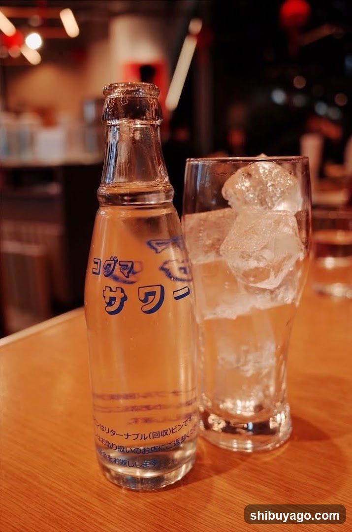 Bottled water and ice glass on table