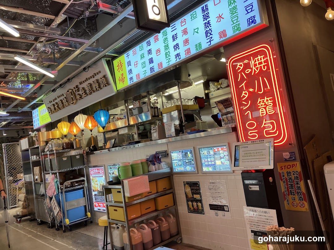 Food stall interior with neon signs and menu boards