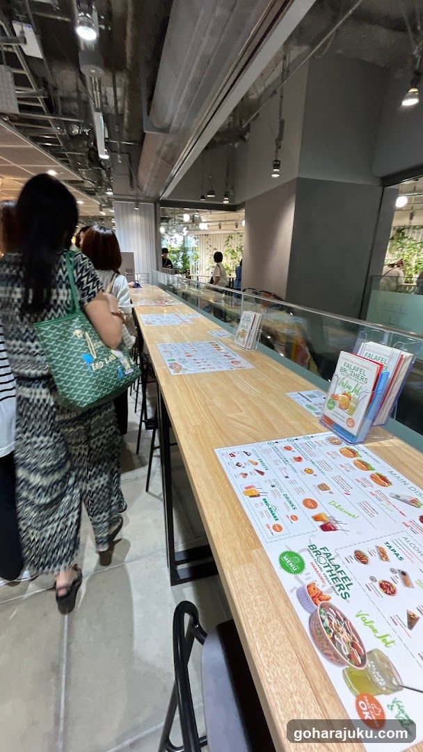 Interior of a cafe or restaurant with long wooden counter and menus
