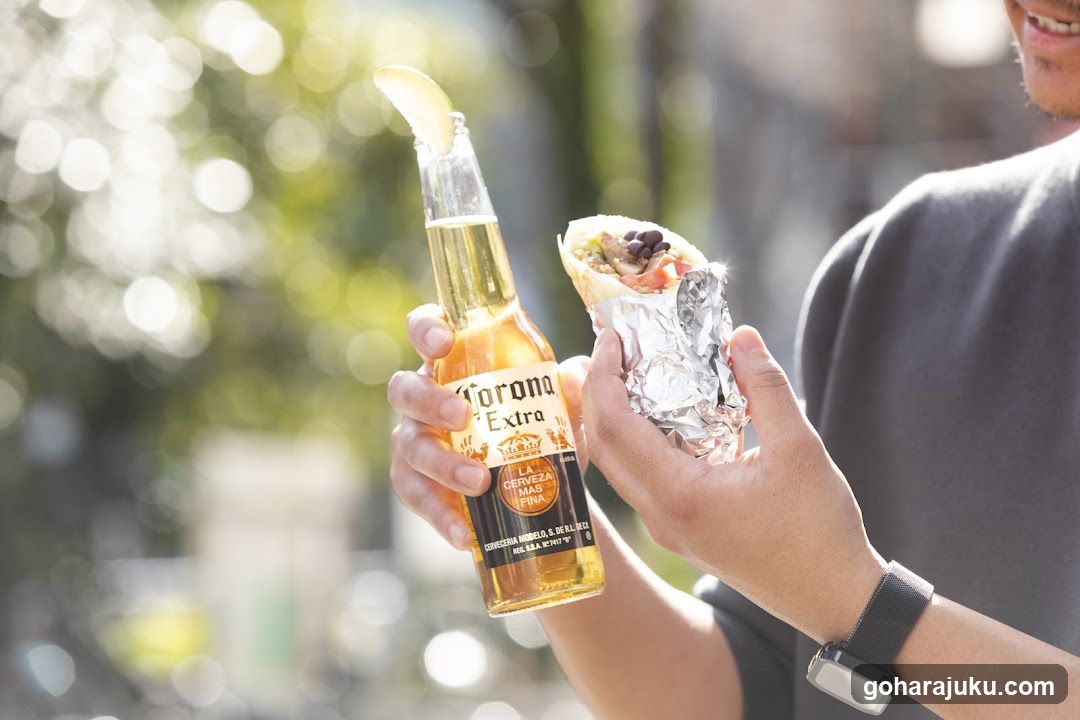 Person holding beer and burrito