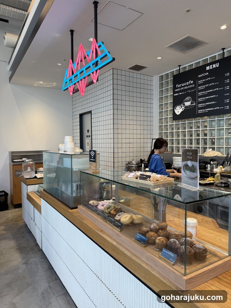 Interior of a modern cafe with pastry display and menu board