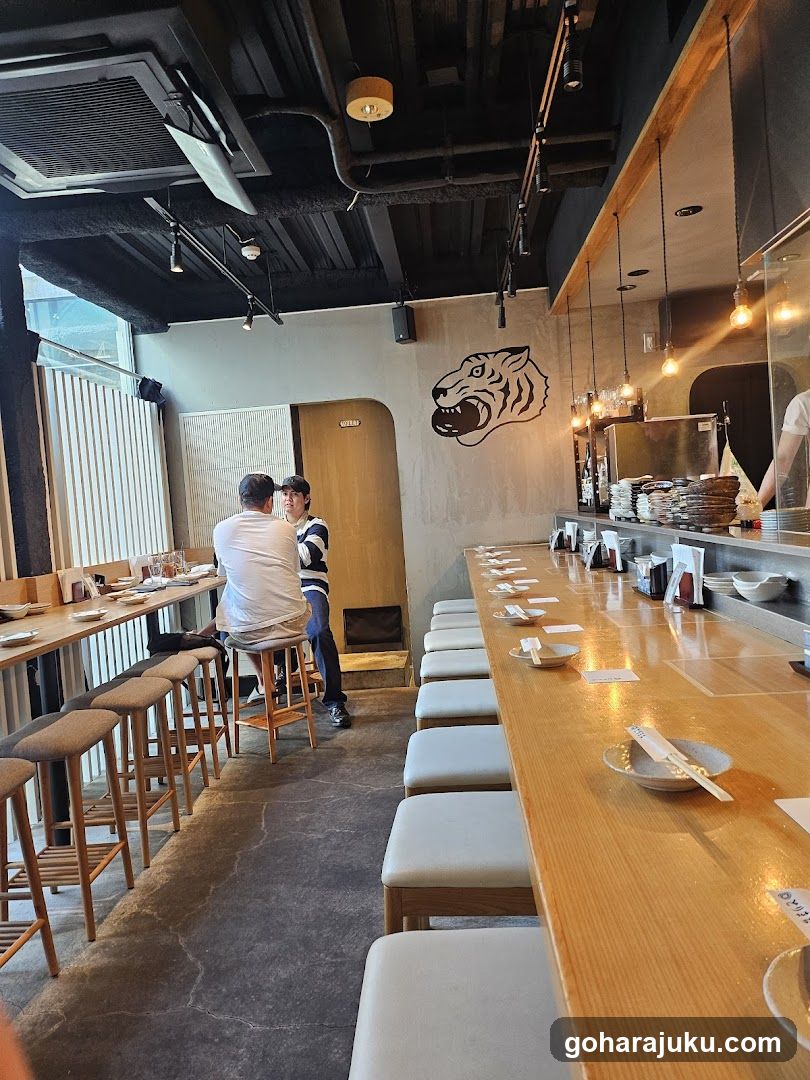 Interior of a Japanese restaurant with bar seating and tiger mural
