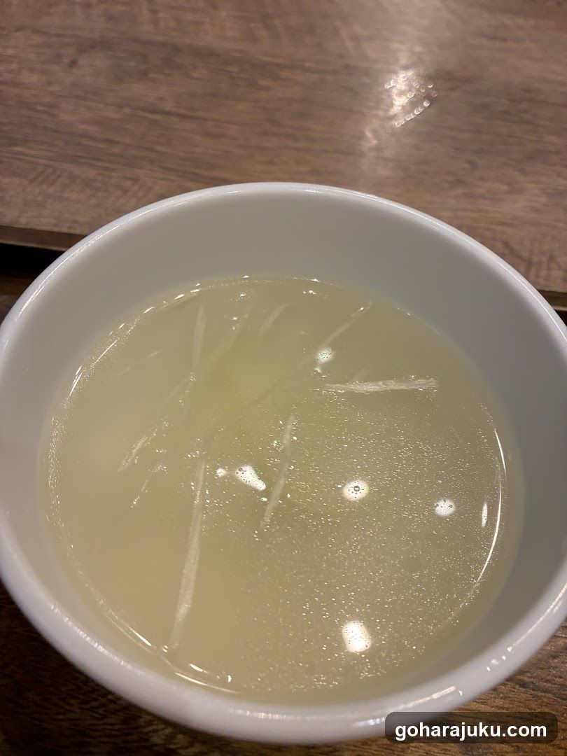 Bowl of clear soup with shredded ingredients