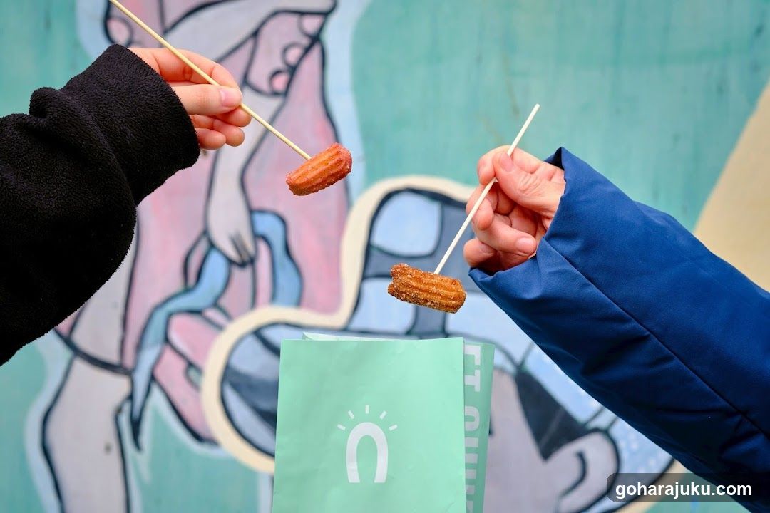 Churros on sticks with a bag in the foreground