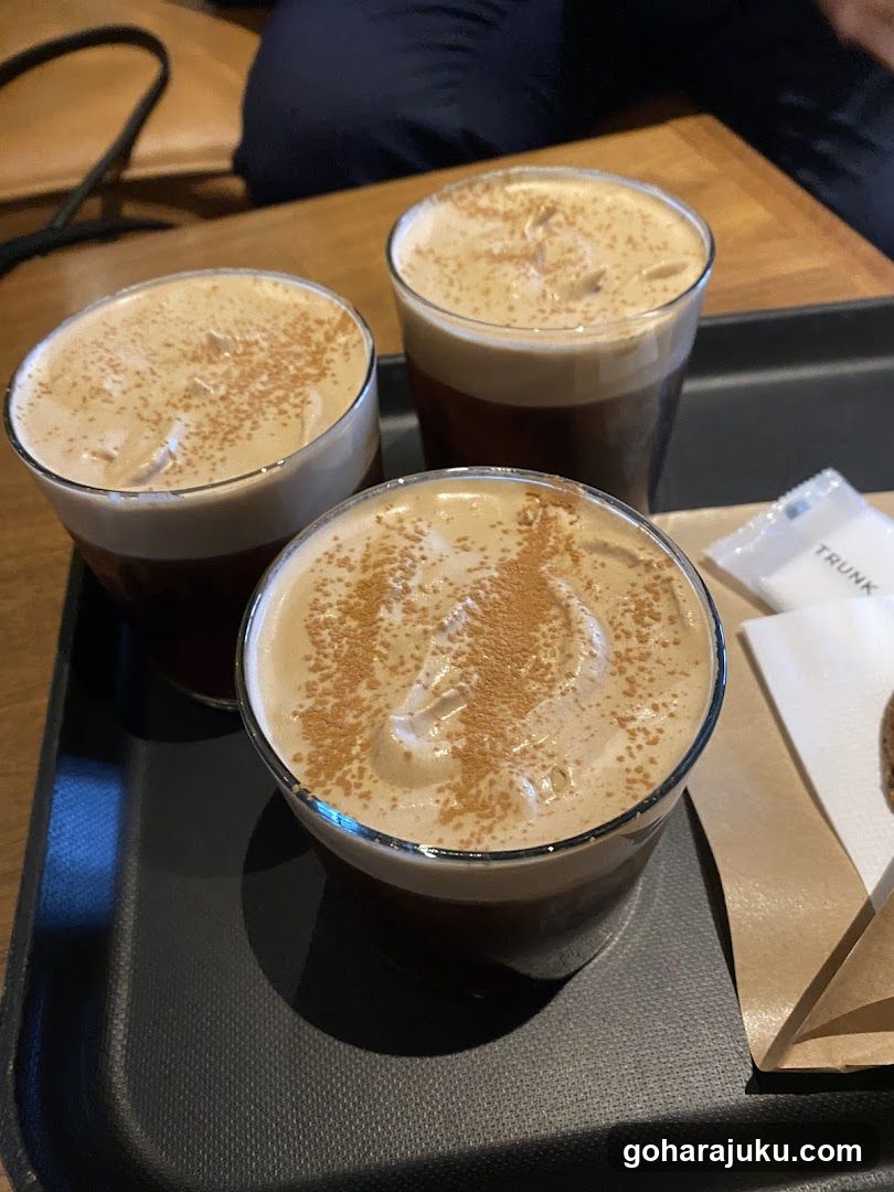 Three glasses of iced coffee with cinnamon dusting on a tray