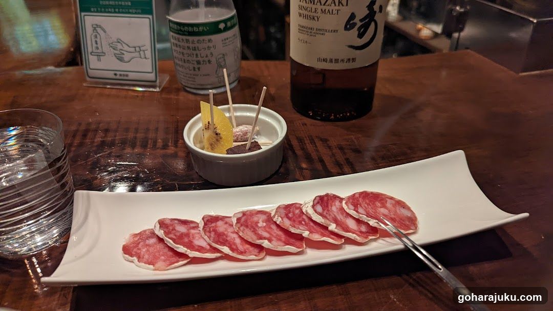 Sliced Meat and Whisky on a Wooden Table