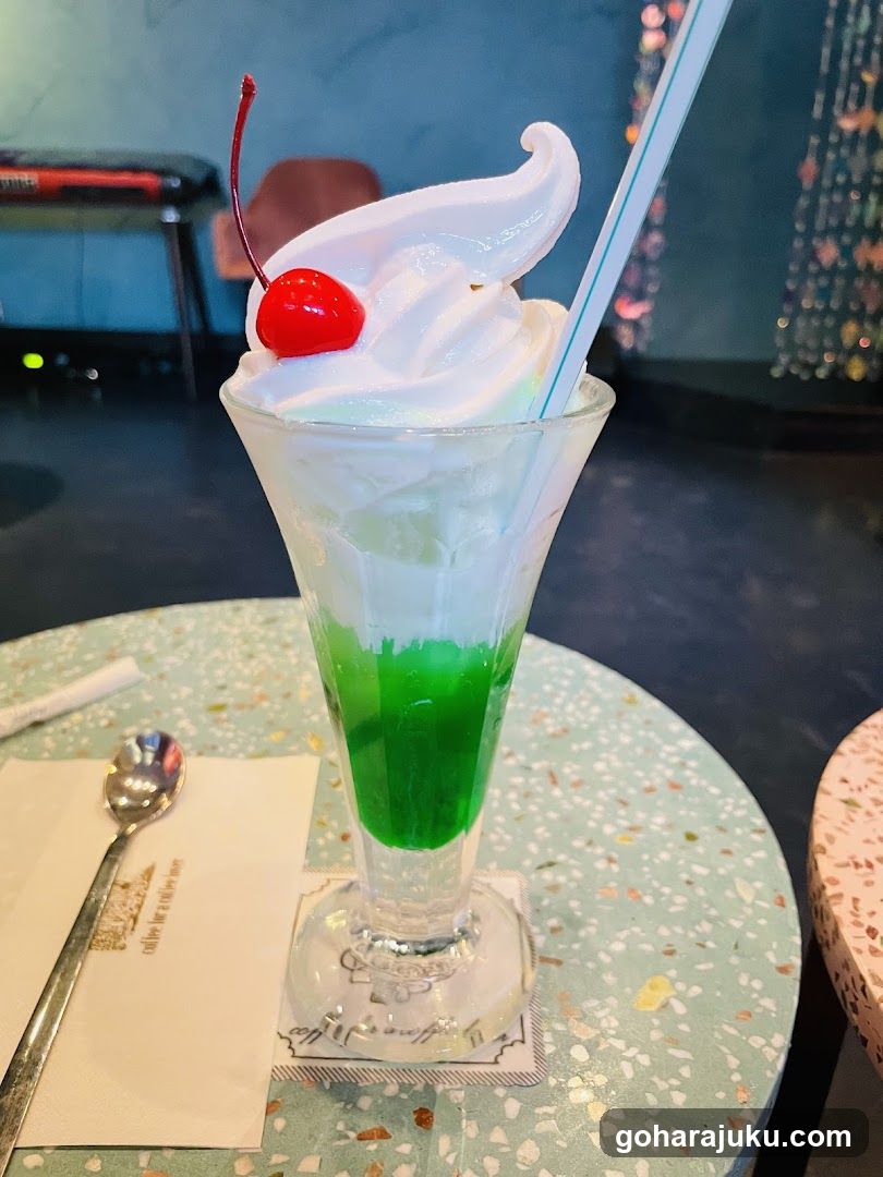 Green layered dessert with whipped cream and cherry