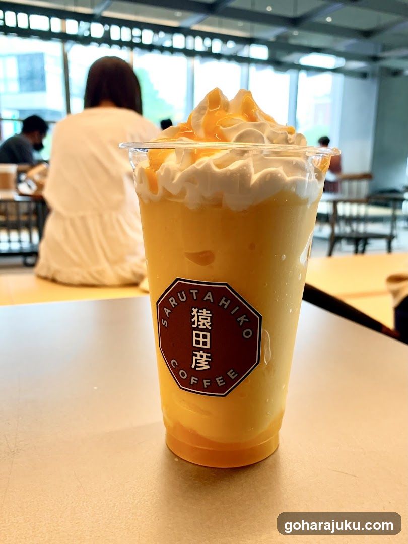 Cup of yellow drink with whipped cream