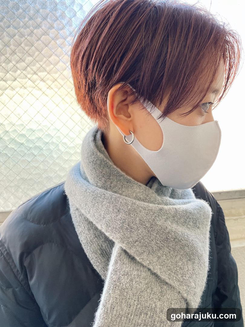 Person with short hair wearing mask and scarf