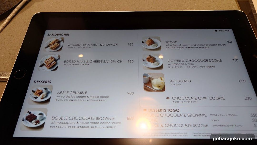 A tablet screen showing a cafe menu with sandwich and dessert options, including prices in yen.
