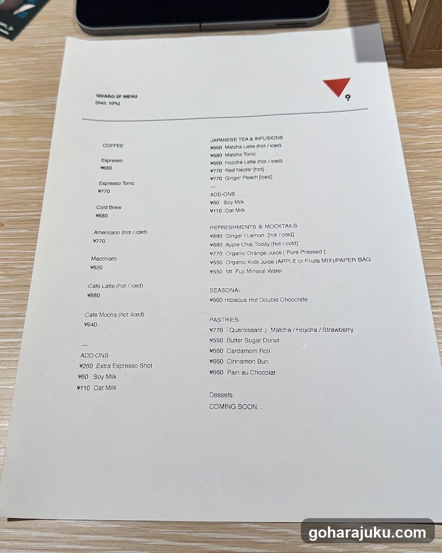 A printed menu listing coffee, Japanese tea, mocktails, pastries, and desserts with prices in Yen.