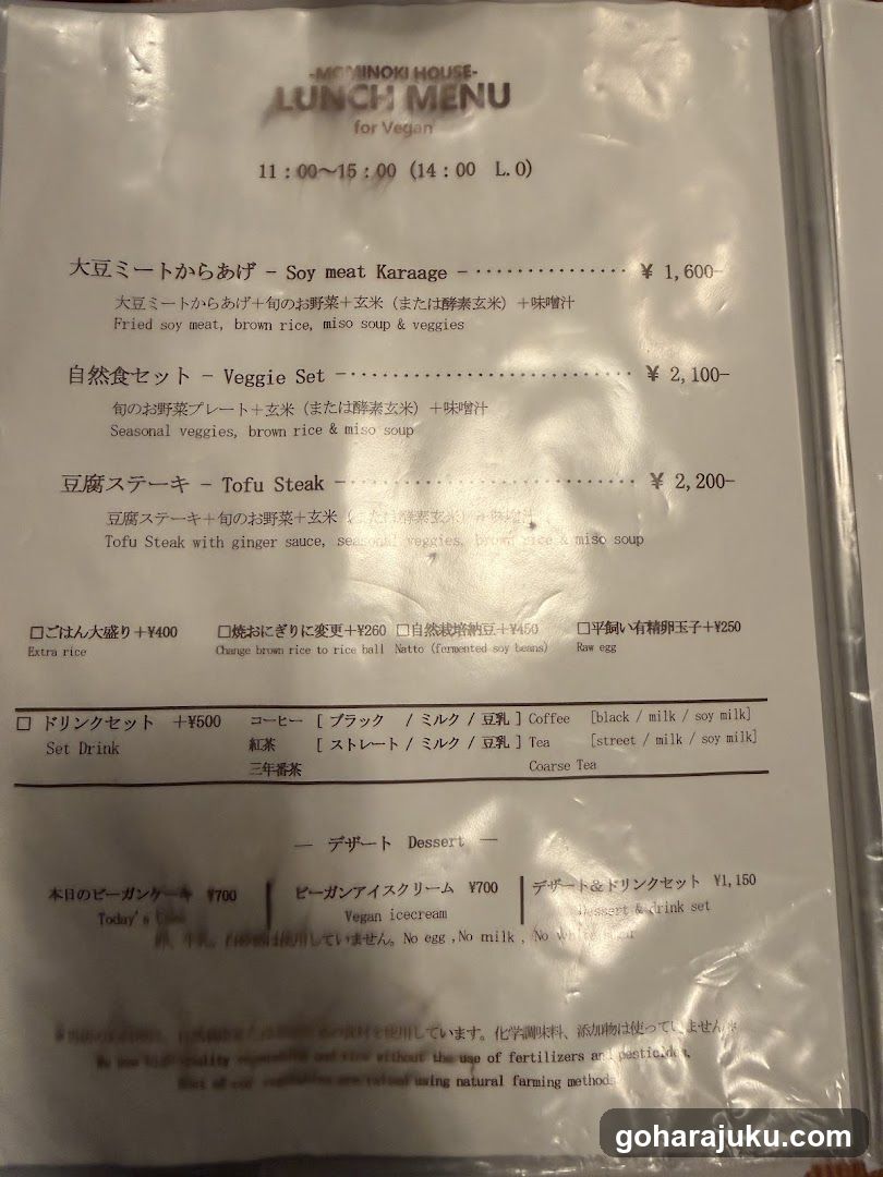 A laminated menu from Mininoi House, featuring vegan lunch options including Soy Meat Karaage, Veggie Set, Tofu Steak, and various drink sets.