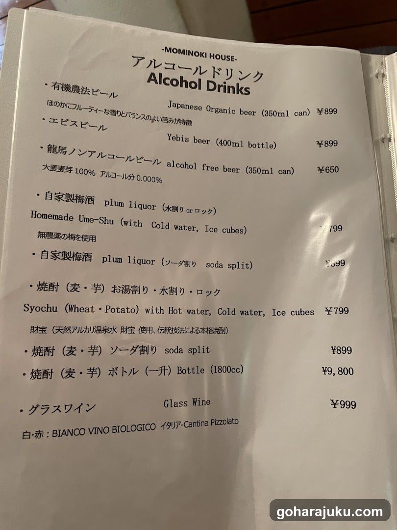 A printed menu page from Mominoki House featuring a list of alcohol drinks, including Japanese organic beer, Yebis beer, alcohol-free beer, homemade plum liquor (plum shu), soychu with various serving options, and glass wine.