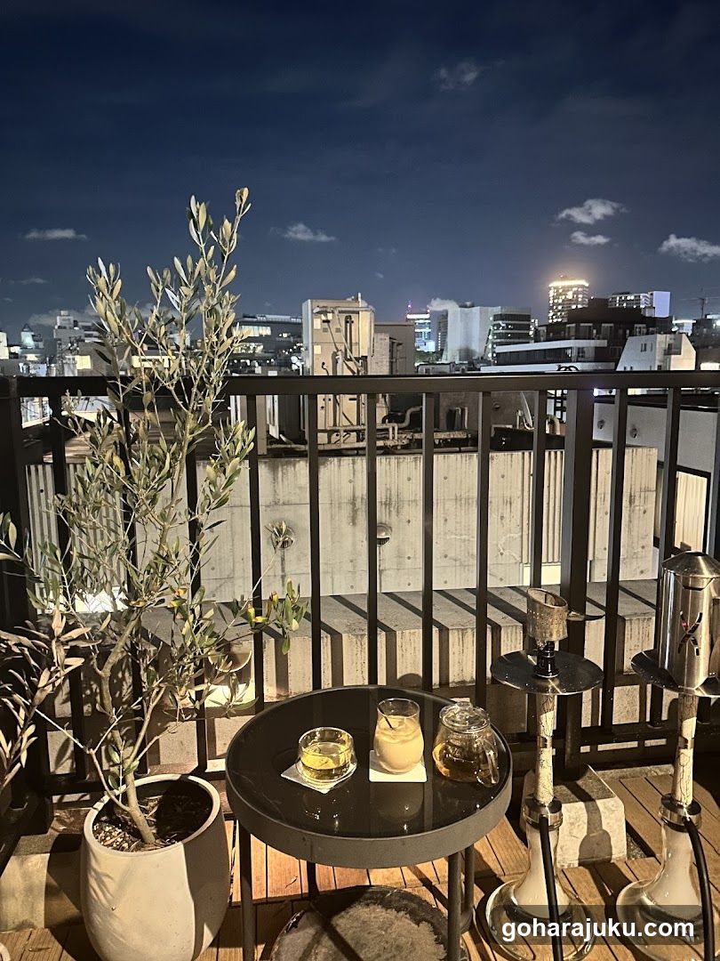 Rooftop Night Scene with Drinks and Hookahs
