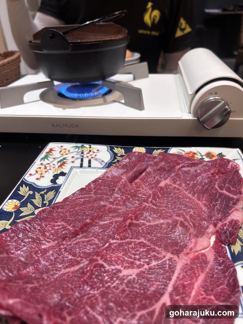 Raw Beef Slices on Plate with Balmuda Burner in Background