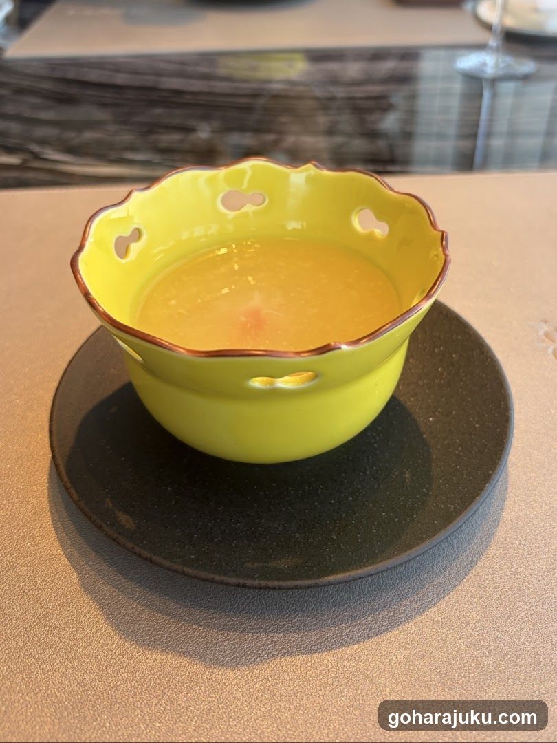 Yellow bowl with soup on a dark plate